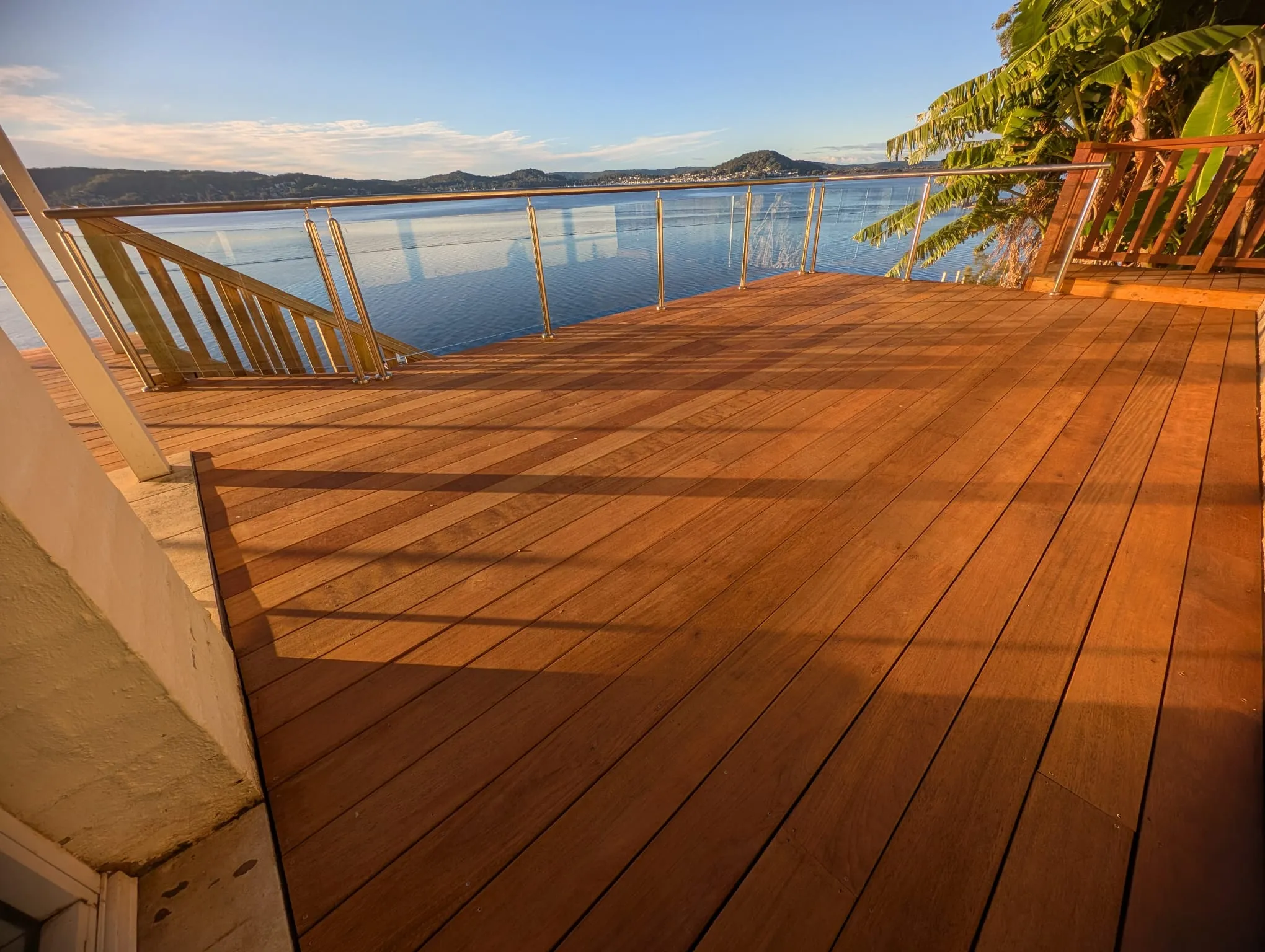 Merbau timber deck with a glass balustrade overlooking the water at Point Clare on the Central Coast