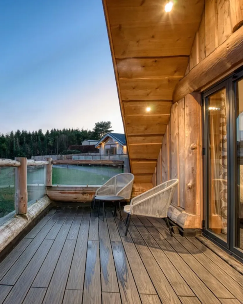 Composite decking on an elevated balcony beside timber cladding, with a spa at dusk