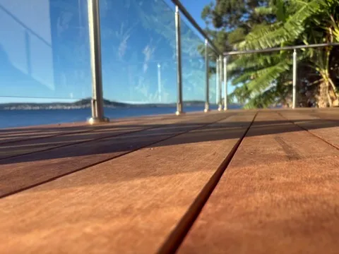 A newly installed merbau deck with a glass balustrade overlooking the water