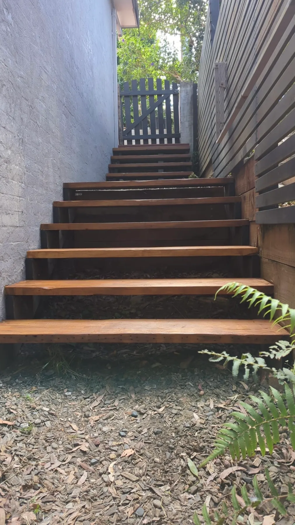 Custom merbau hardwood access stairs running down the side of a house